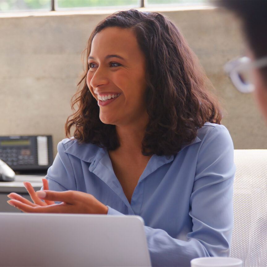 Close Up Of Business Team Meeting Around Table In Modern Office For Presentation